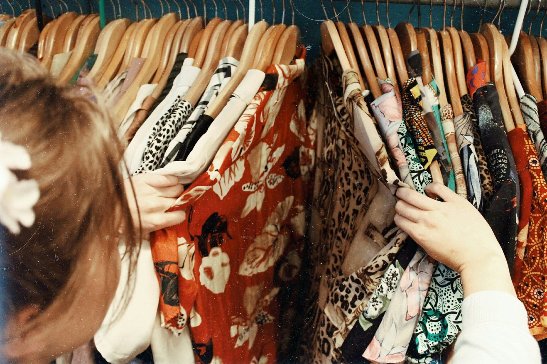 Estilista ayudando a un cliente con compras personales, seleccionando atuendos en una boutique